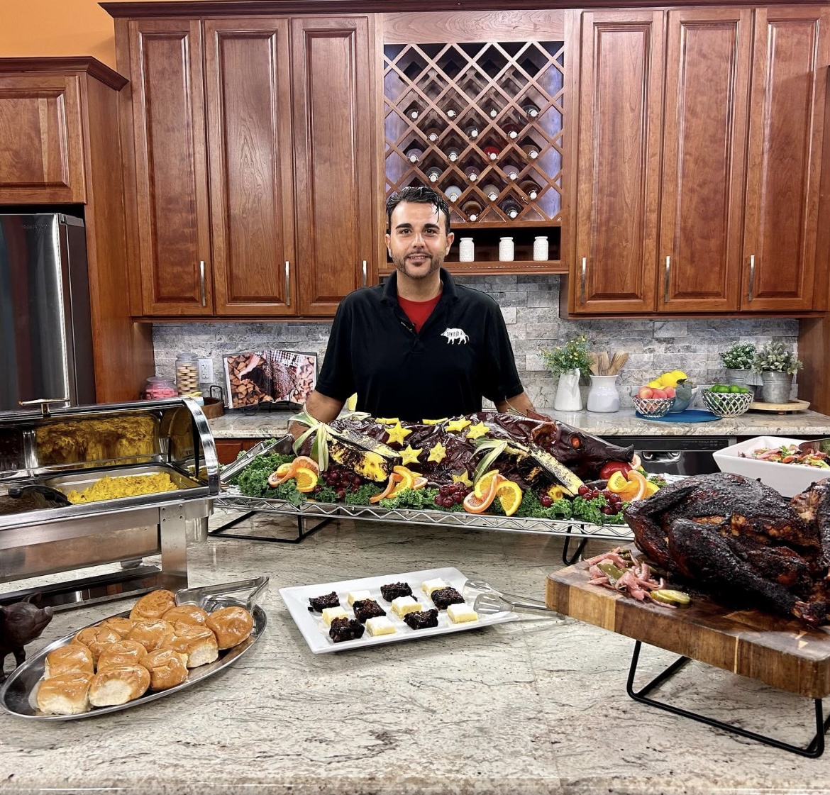 Chef Alex Planchart behind an abundant whole-hog catering spread